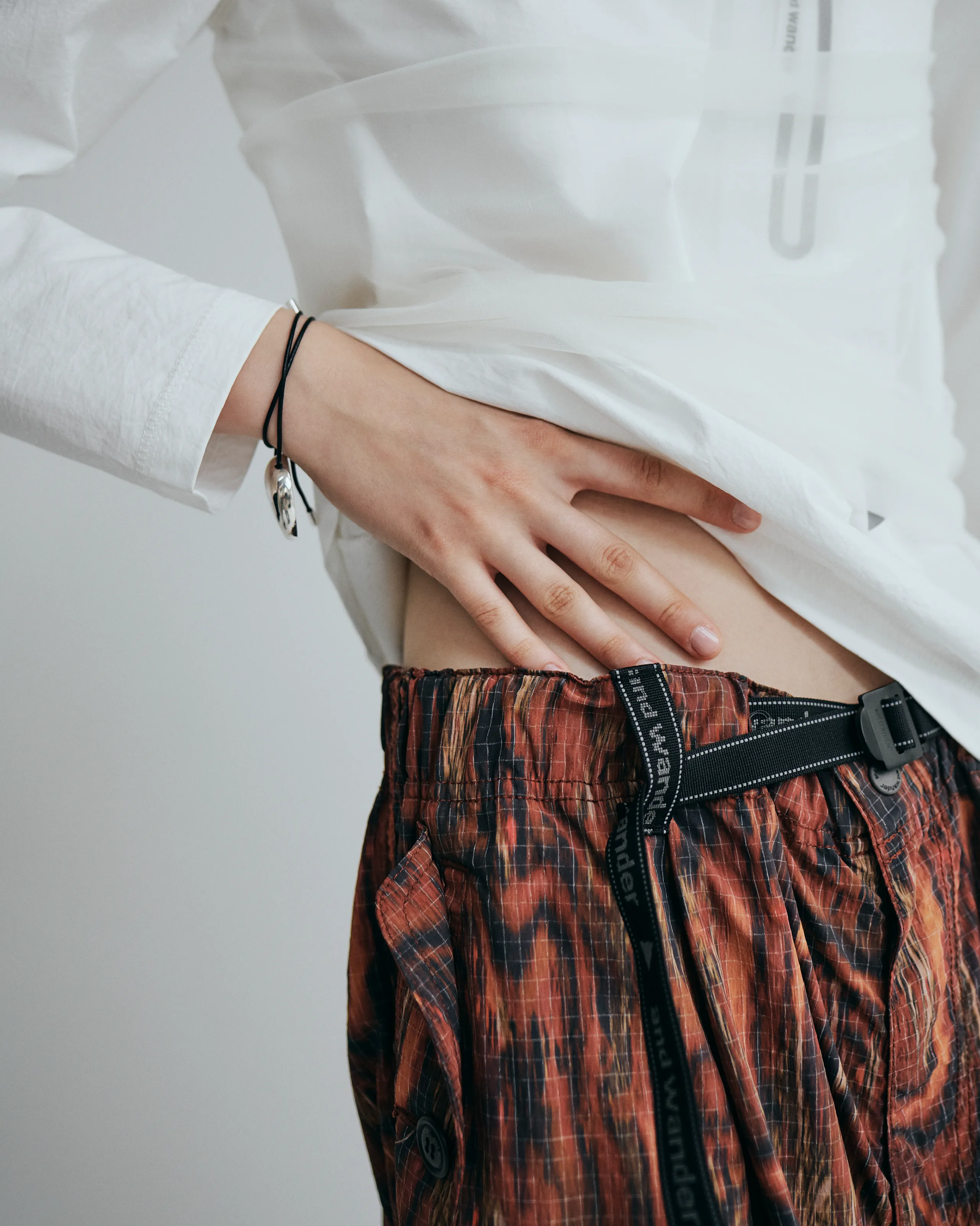 白のトップスと柄のパンツのコーデ